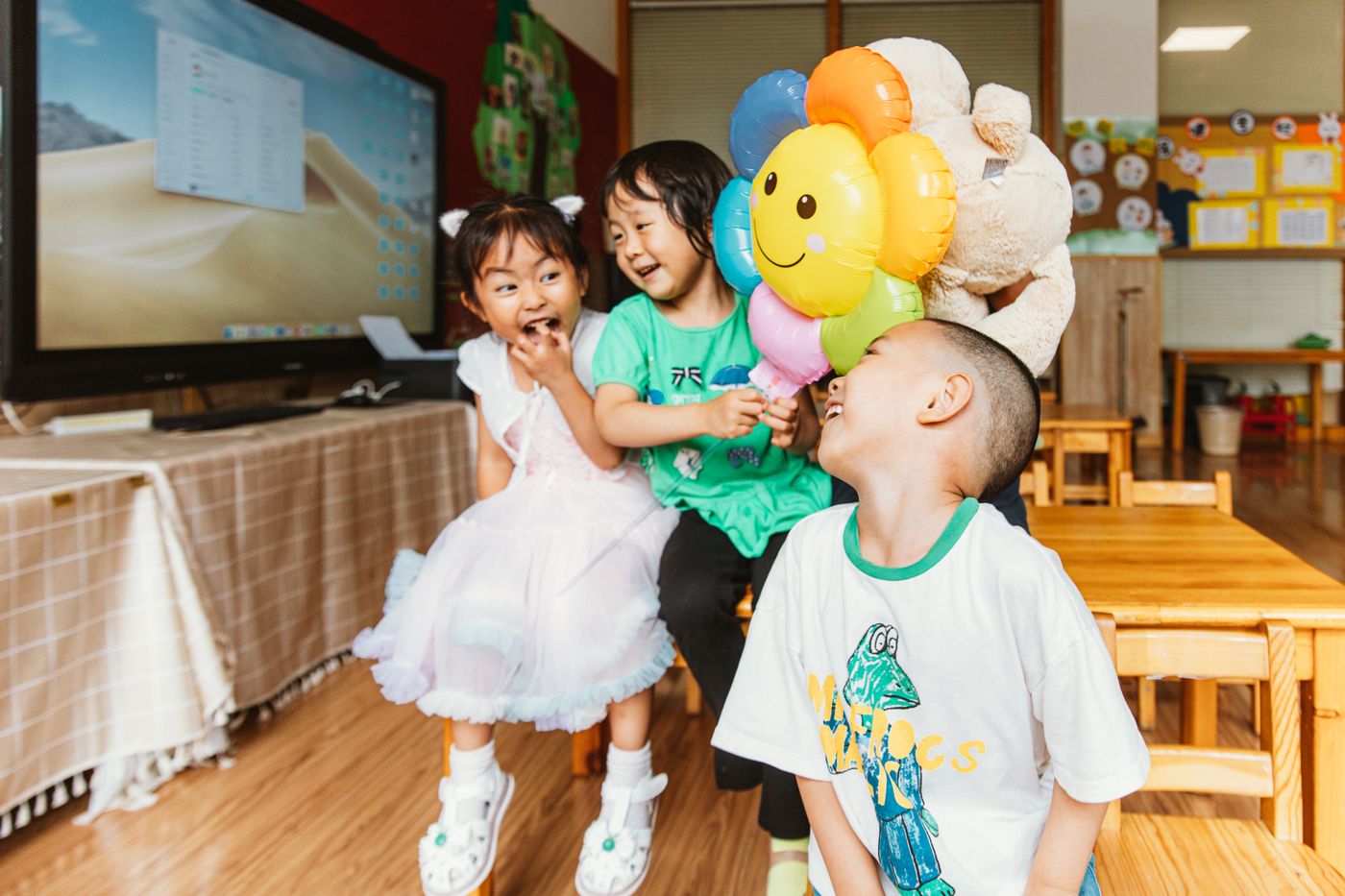 保育室で風船を持って笑う子どもたち